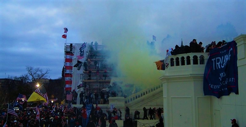 Tear gas being deployed against pro-Trump rioters on the steps of the U.S. Capitol building. A "Trump 2020" banner hangs over the banister. (Blog Post: "Employment At Will" in Illinois)